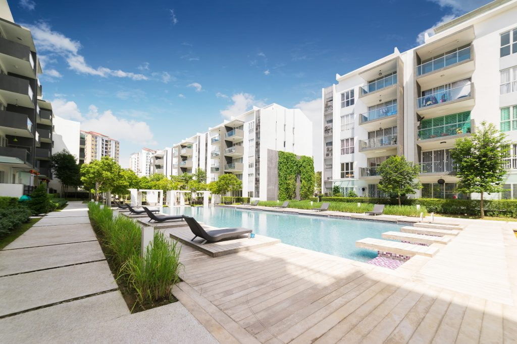 Modern looking pool surrounded by upscale multi-housing building. 